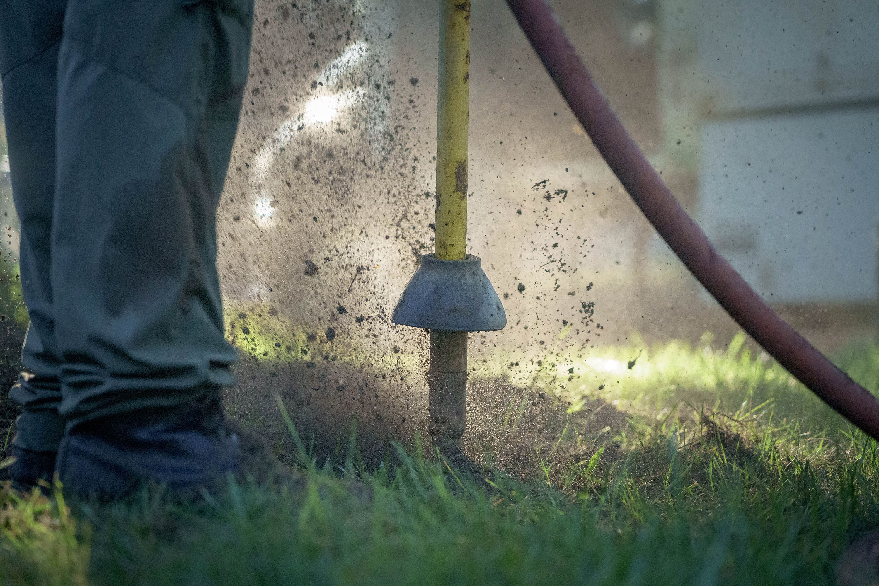 Treecologist using an air spade to loosen compacted soil
